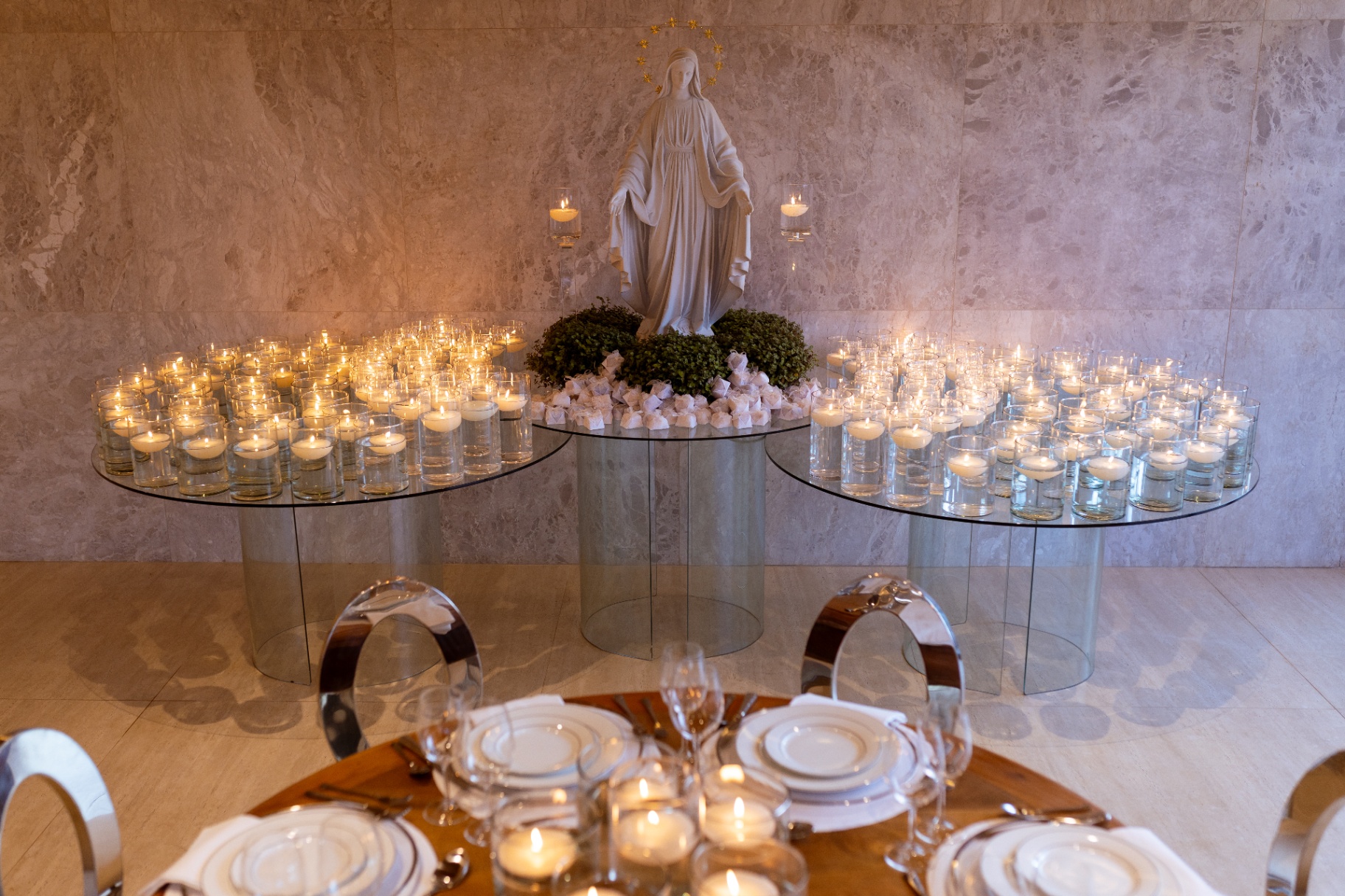 Ambiente interno do espaço Icon com decoração clássica, velas e estátua religiosa.